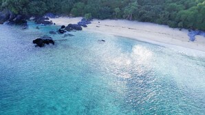 An aerial view of a beach with clear turquoise waters, rocky outcrops, and a sandy shoreline. - ima villa (Onna)