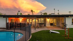 Uma casa moderna com piscina, área de estar externa e decoração com tema de cactos.