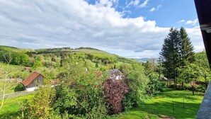 A rural landscape with a house, a path, and a hill. - Apartment 'Fewo Zuckerfeld' with Shared Terrace and Wi-Fi (Gersfeld (Rhön))