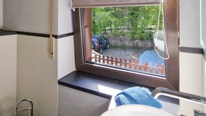 A bathroom with a window, a sink, and a toilet. - Apartment 'Fewo Zuckerfeld' with Shared Terrace and Wi-Fi (Gersfeld (Rhön))