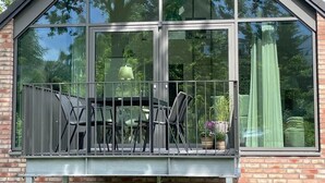 A modern building with a large glass balcony, a brick facade, and a triangular roof. - Apartment 'Meerzeit' with Sea View, Balcony and Wi-Fi (Eckernförde)
