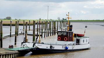 A boat docked at a pier with a wooden structure in the background.