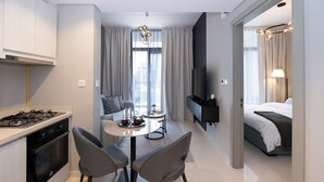 Una habitación de hotel moderna con cocina, comedor y cama.