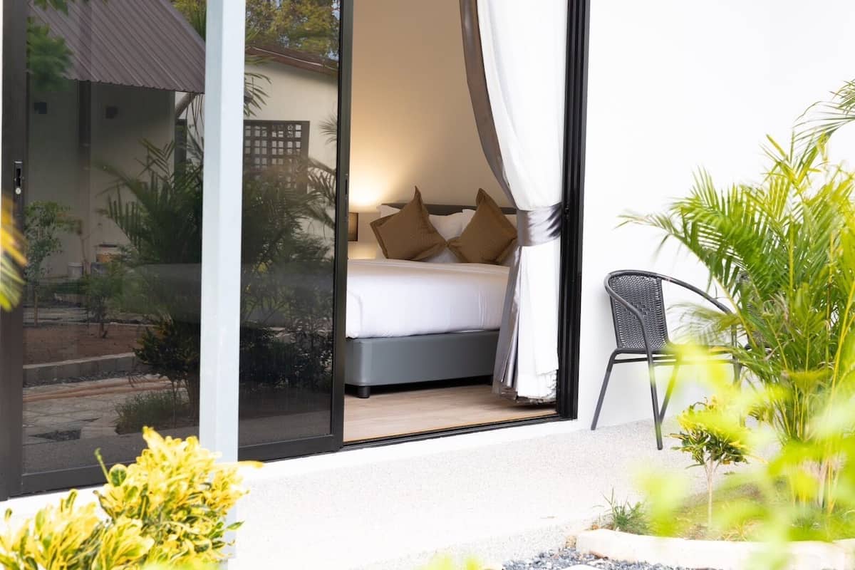 Une chambre à coucher avec un lit, des oreillers et une chaise.