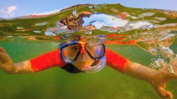 Una persona nadando bajo el agua con gafas.