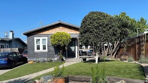 A residential house with a front yard, a driveway, and a car parked on the street. - Beautiful Normal Heights Living (San Diego)
