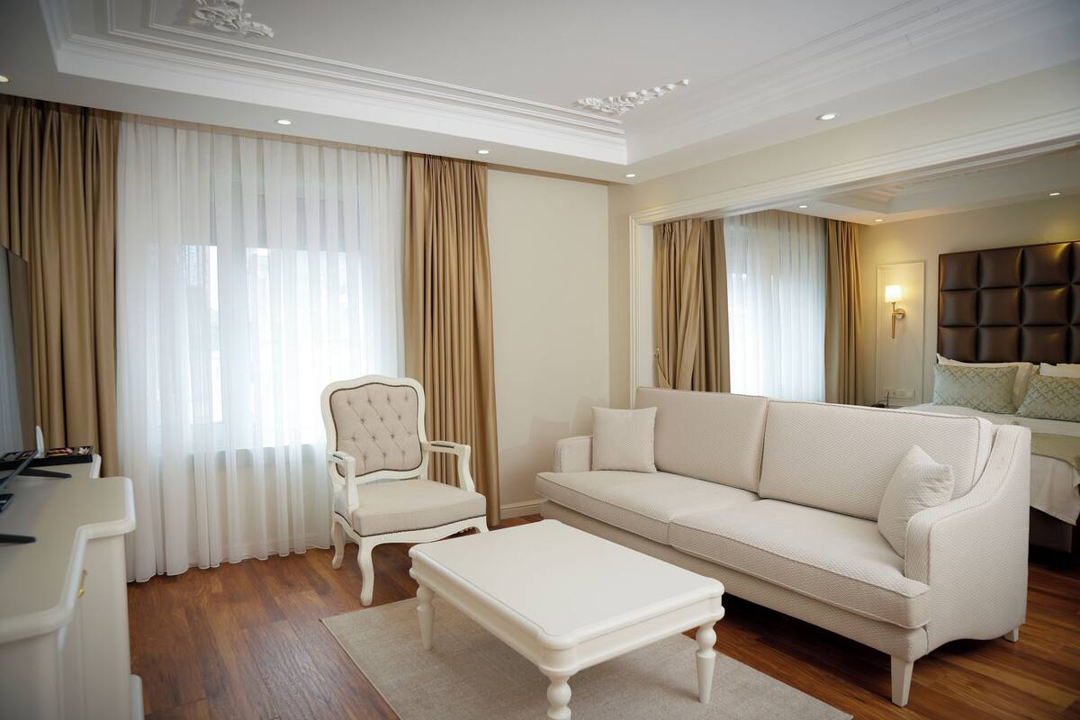 A spacious living room with a white sofa, a matching armchair, and a coffee table.