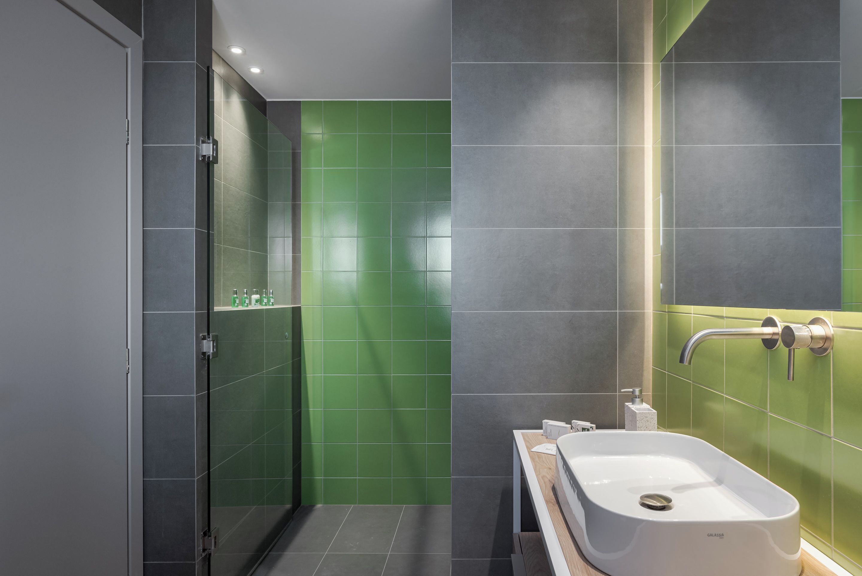 Une salle de bain moderne dotée d’une douche à parois de verre, d’une baignoire sur pieds et d’un meuble-lavabo avec miroir.