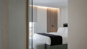 A modern bedroom with a bed, a bench, and a wardrobe. - Acropolis Iconic Estate (Athens)