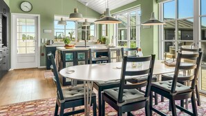 Una cocina amplia con una isla grande, iluminación colgante y vistas al exterior.