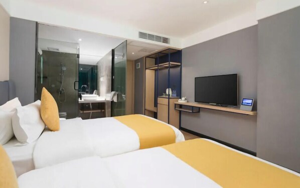A hotel room with two beds, a TV, a desk, and a bathroom visible through a glass partition. - Puyue Hotel - Shenzhen East Railway Station Buji Metro Station (Shenzhen)