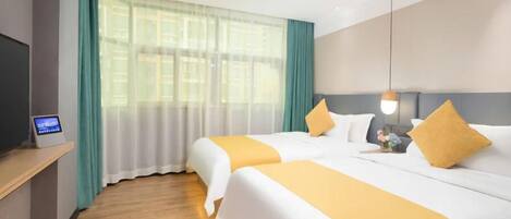 A hotel room with two beds, a TV on a stand, and a window with curtains.