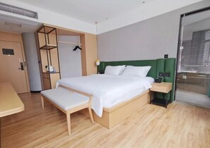 A modern hotel room with a wooden bed, a bench, a bedside table, and a wardrobe with a mirror. - Puyue Hotel - Shenzhen East Railway Station Buji Metro Station (Shenzhen)