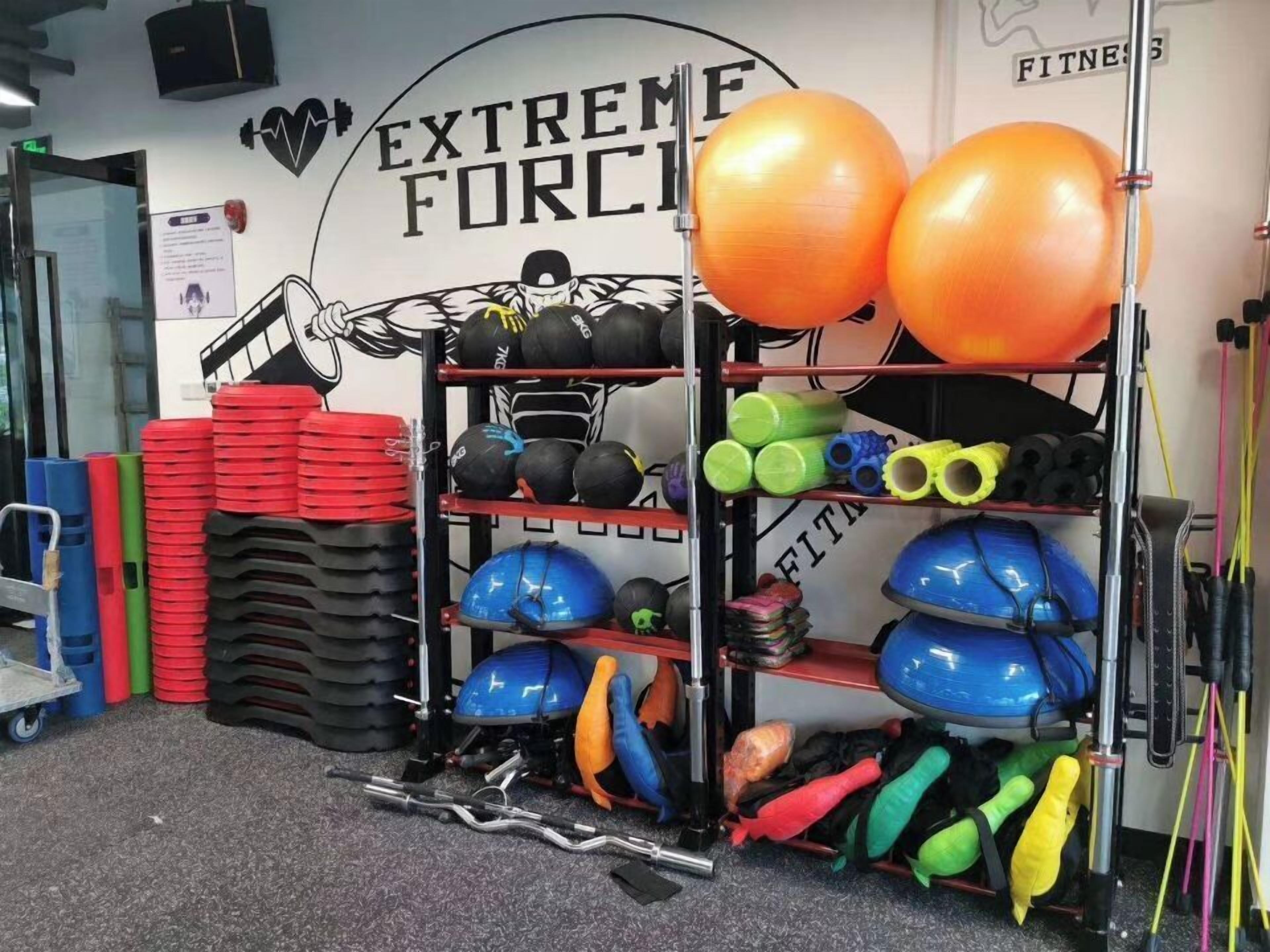 A gym with exercise equipment, including dumbbells, medicine balls, and resistance bands.