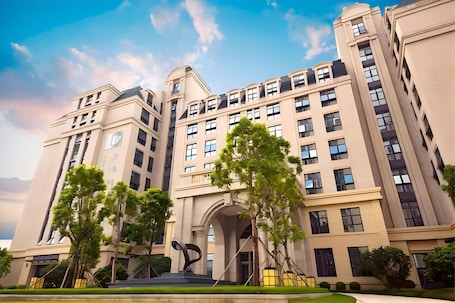 A multi-story building with a symmetrical facade, large windows, and a central entrance with a decorative arch.