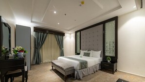 A modern bedroom with a bed, bedside tables, a dresser, and a mirror. - Holiday Plus Al Nuzha (Jeddah)
