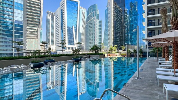 A swimming pool with a clear view of modern high-rise buildings in the background. - Spectacular Views 1BR Apt Business Bay (Dubai)