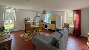 A compact living space with a dining area, kitchenette, and a grey sofa. - Apartment Chateau Rouge  (La Londe-les-Maures)