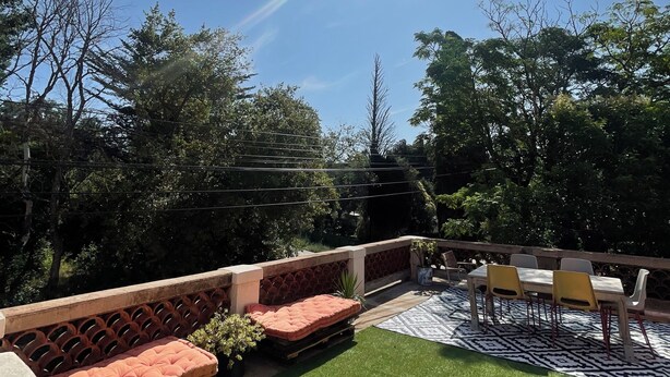 An outdoor patio with artificial grass, a cushioned seating area, and a table with chairs. - Apartment Chateau Rouge  (La Londe-les-Maures)