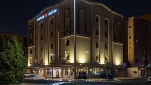 Ein Hotel mit moderner Fassade, zahlreichen Fenstern und einem gut beleuchteten Eingang.