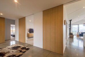A modern interior with a wooden partition, a leather rug, and a view of a mountain landscape through large windows. - Lake View Heights - Luxury large modern House (244 sq mtr) (Wanaka)