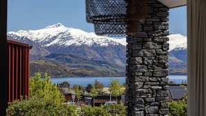 A view of a mountain range with snow-capped peaks and a body of water in the foreground. - Lake View Heights - Luxury large modern House (244 sq mtr)  (Wanaka)