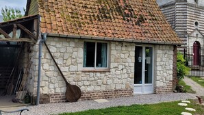 A stone house with a tiled roof, a wooden door, and a window. - Maison 1810, the charm of old stones. (Fosseux)
