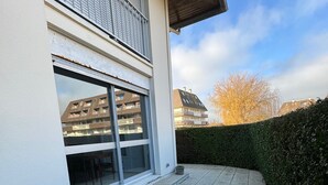Ein modernes Gebäude mit einer großen Glastür und einer gepflasterten Terrasse.