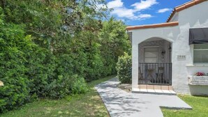 A house with a paved driveway leading to a covered entrance. - Heart of Calle 8 | Spacious 2/2 for Families (Miami)