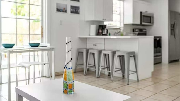 A modern kitchen with white cabinets, a central island with stools, and a dining area with a white table and chairs. - Heart of Calle 8 | Spacious 2/2 for Families (Miami)
