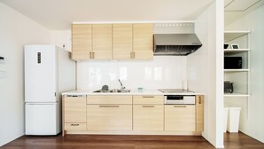Una cucina moderna con mobili in legno, un frigorifero bianco e una lavastoviglie.