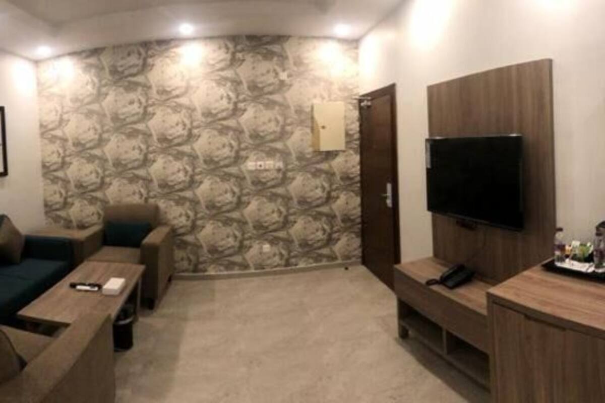 A living room with a sofa, coffee table, TV, and a wooden cabinet.
