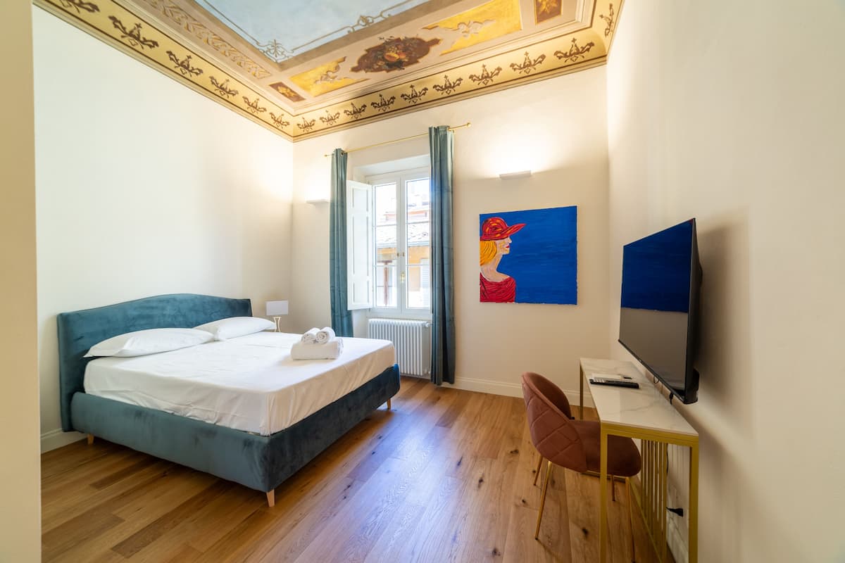 Une chambre à coucher avec un lit, une télévision et un bureau.