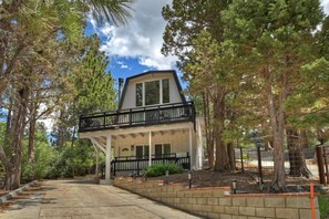A two-story building with a balcony, surrounded by trees. - Summit View Treehouse By Destination Big Bear: Pet Friendly! Close to Bear Mtn! Walking Distance to Alpine Zoo! (Big Bear Lake)