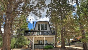 A two-story house with a balcony, surrounded by trees. - Summit View Treehouse By Destination Big Bear: Pet Friendly! Close to Bear Mtn! Walking Distance to Alpine Zoo! (Big Bear Lake)