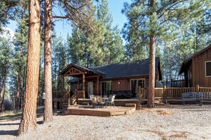 Une cabane en bois avec un porche, un espace salon extérieur et une terrasse.