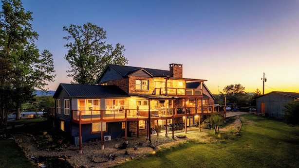 A large two-story house with a balcony, a chimney, and a well-maintained lawn. - Private Pond, Weddings for up to 100! Pool is open (Sevierville)