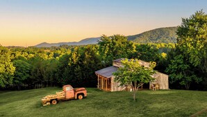 A rural landscape with a barn, a truck, and a tree in a grassy field. - Private Pond, Weddings for up to 100! Pool is open (Sevierville)