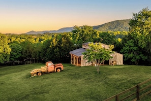 A rural landscape with a barn, a truck, and a tree in a grassy field. - Private Pond, Weddings for up to 100! Pool is open (Sevierville)