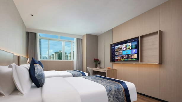A modern hotel room with two beds, a desk, a TV, and a city view. - ShanShui S Hotel (Guangzhou)