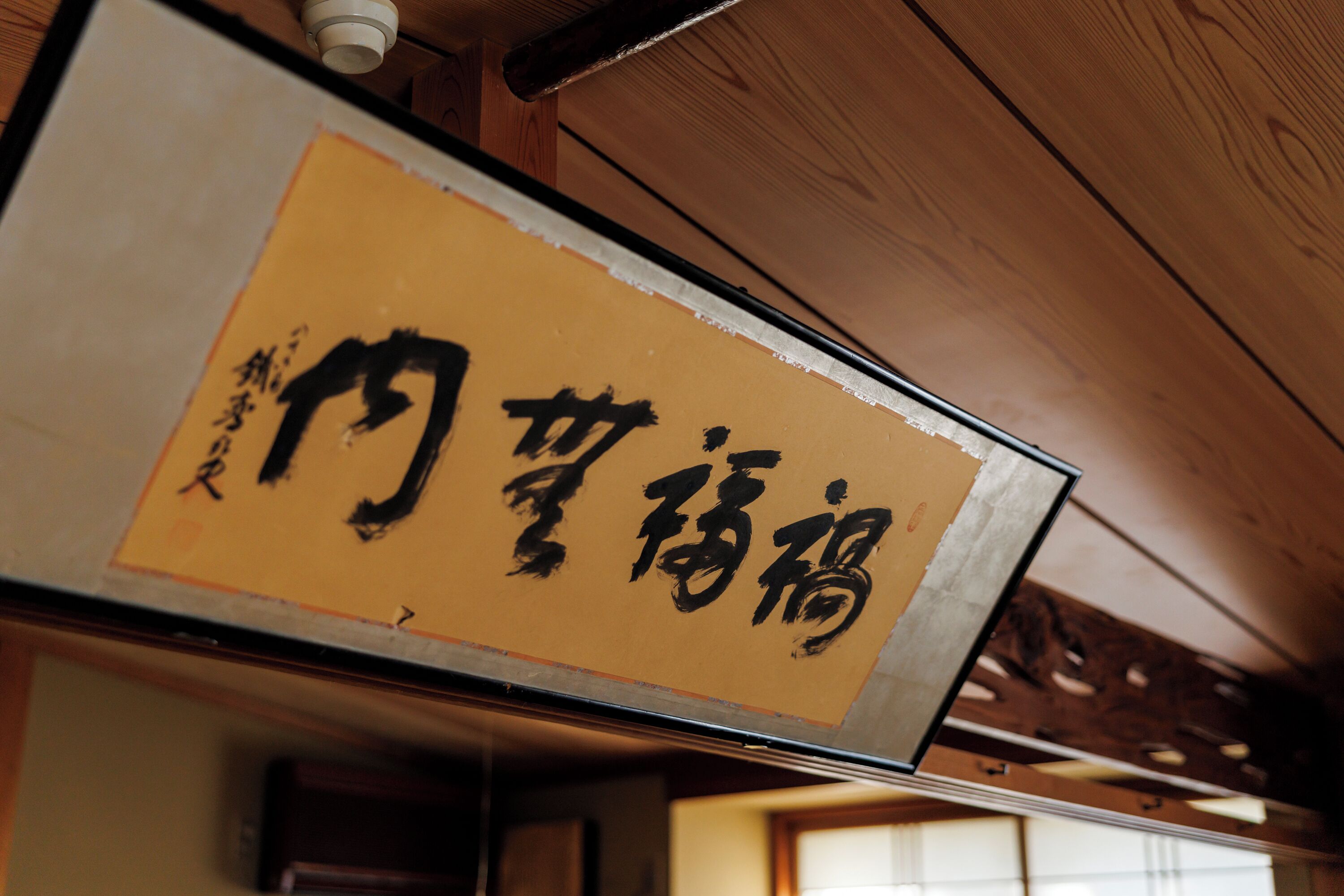 Un panneau affichant des caractères japonais, indiquant un lieu ou un établissement.