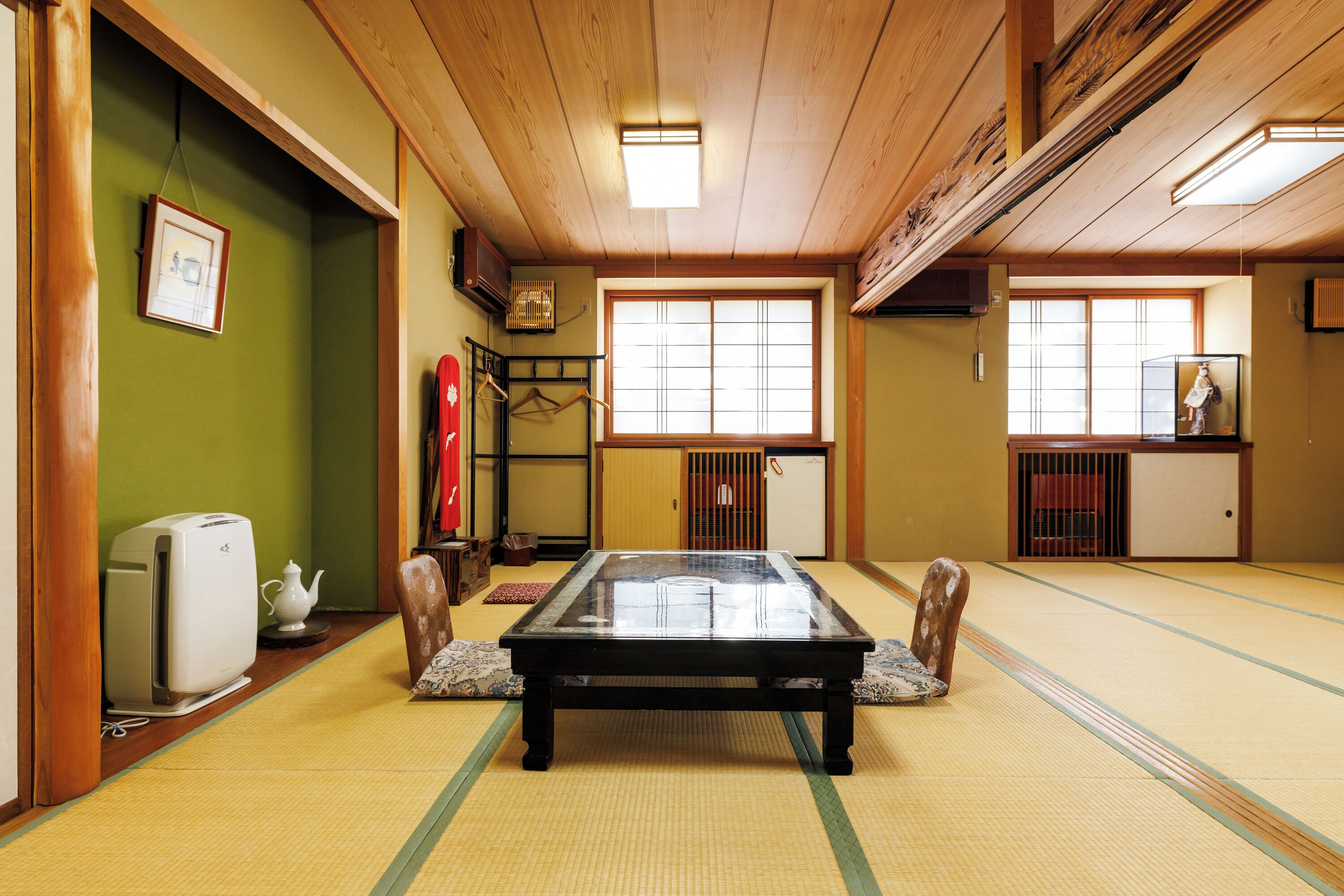 Une pièce avec un sol recouvert de tatamis, une table en tatami, un radiateur et un meuble traditionnel japonais.