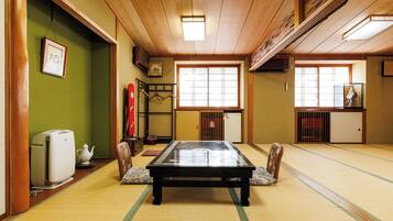 Une pièce avec un sol recouvert de tatamis, une table en tatami, un radiateur et un meuble traditionnel japonais.