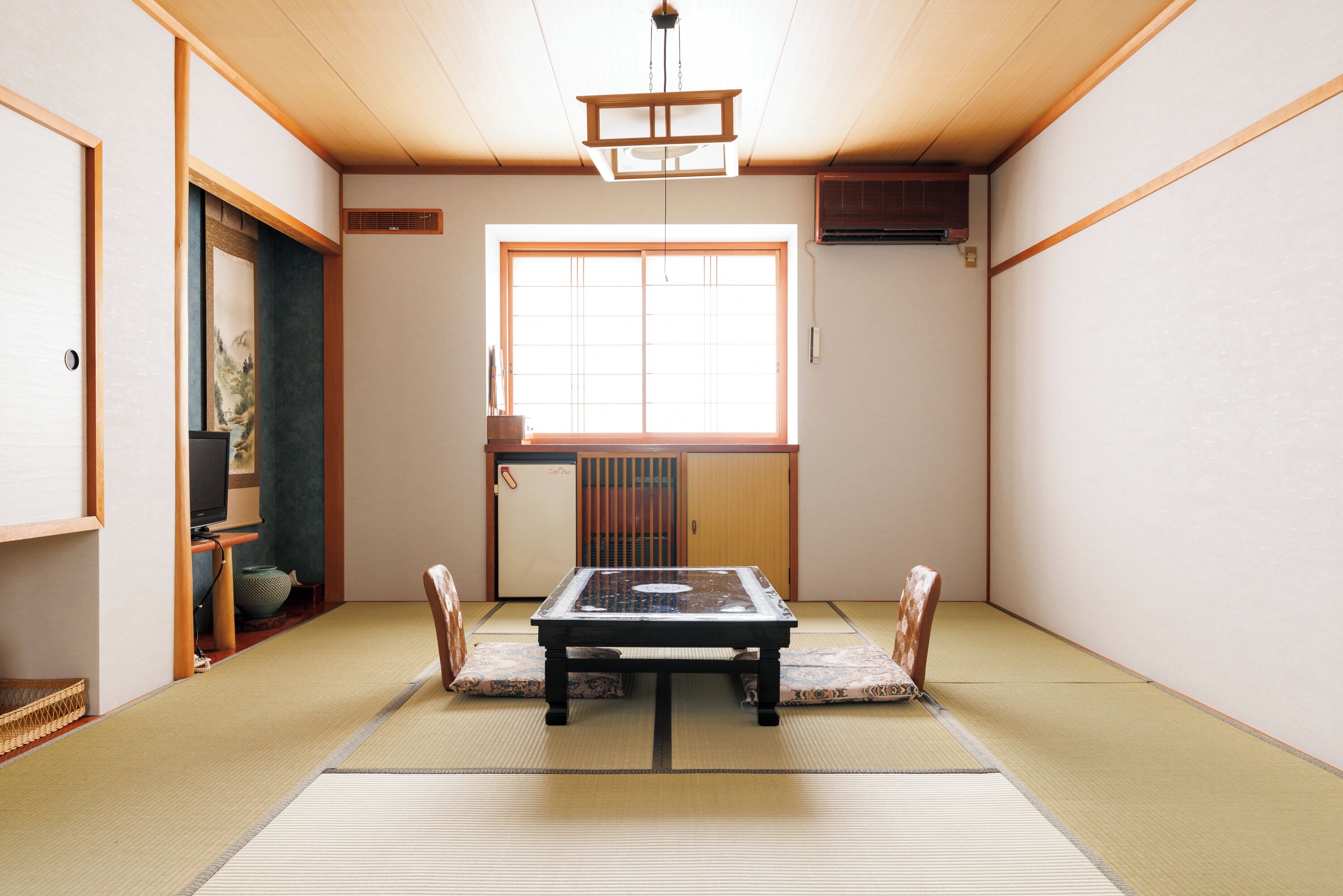 A traditional Japanese room with tatami flooring, a low table, and sliding doors.