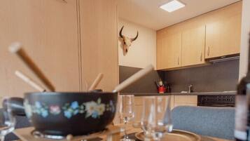 A dining area with a table set for two, featuring a bowl and glasses.