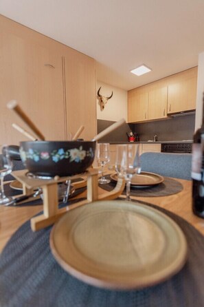 Een eetruimte met een tafel voor twee personen, met een kom en glazen.