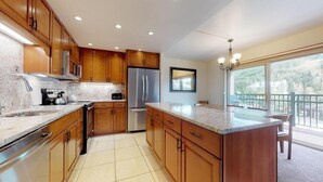 A modern kitchen with wooden cabinets, stainless steel appliances, and a large island.