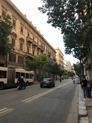 A street lined with historic buildings, a parked bus, and a car. - Little House of Grandpa Antonio (Palermo)