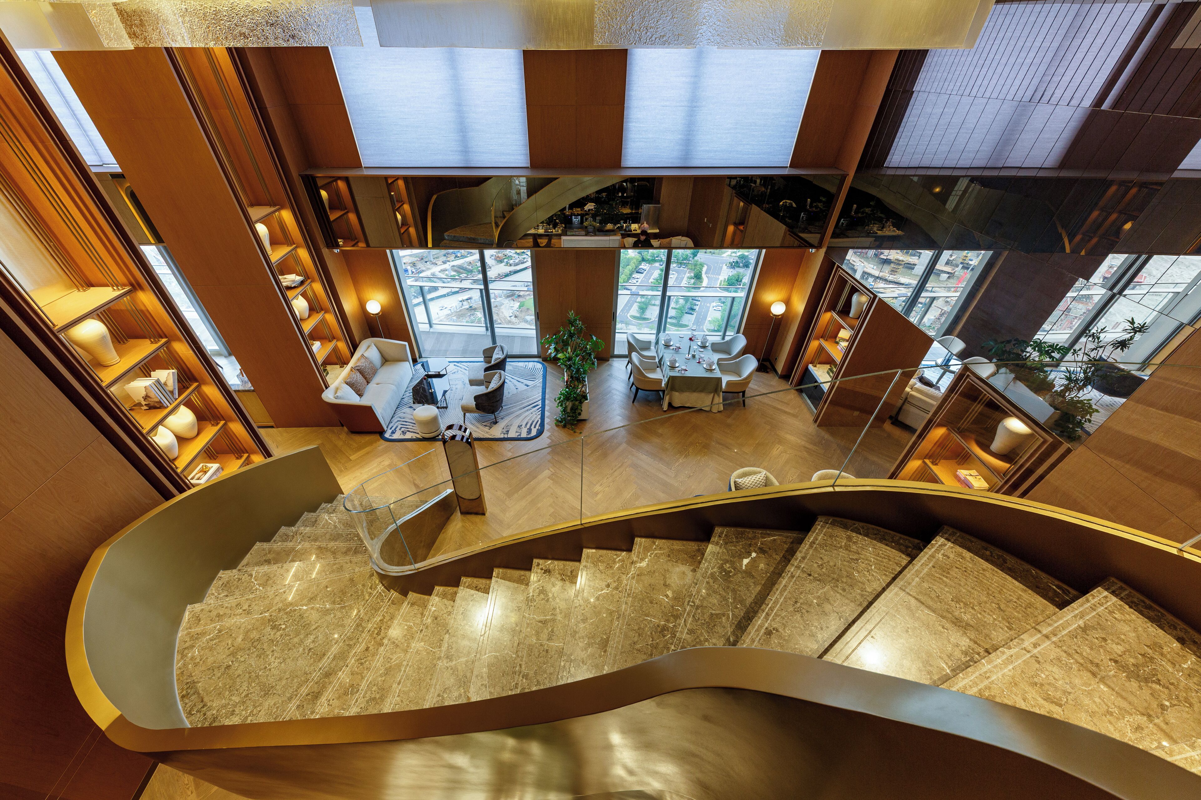 A modern interior with a curved staircase, a dining area with a view, and a bar area.