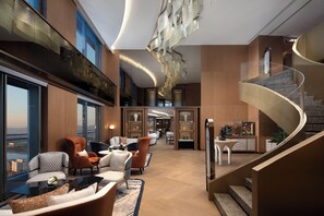 A modern hotel lobby with a curved staircase, seating area, and a bar. - C&D Hotel Donghai Quanzhou  (Quanzhou)